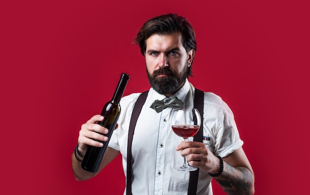 Elegant brutal man in formal wear has groomed hair drinking wine bartender