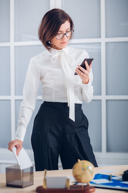 Elegant business woman talking on the phone in the office.