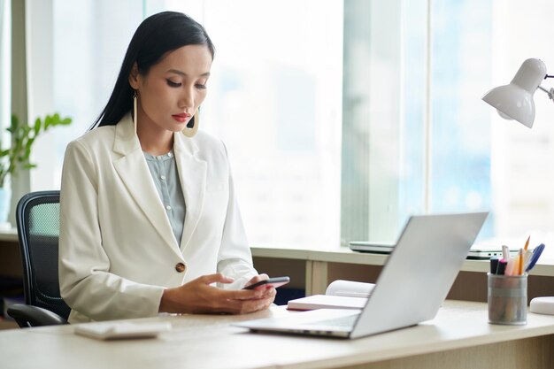 Elegant Businesswoman Checking Smartphone