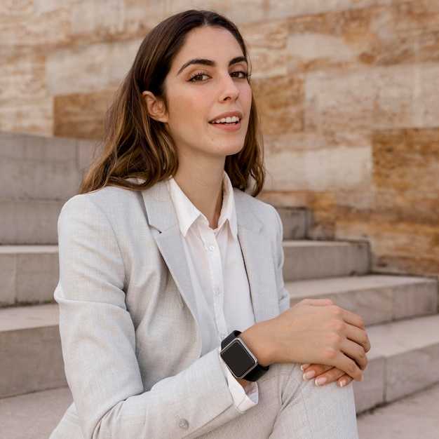 Photo elegant businesswoman posing outdoors on stairs