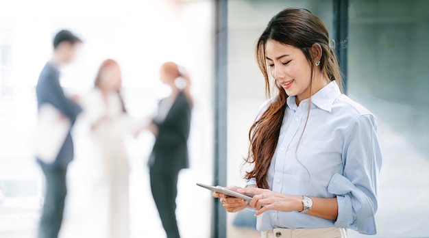 Elegant businesswoman standing in office with digital tablet