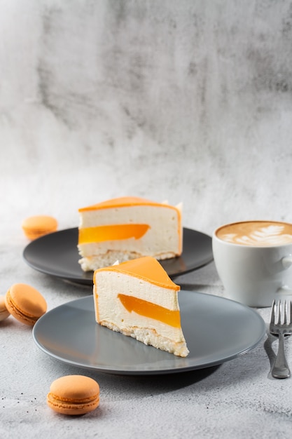 Elegant Cake with coconut, passion fruit, mangoes and bananas, covered with chocolate glaze. Slice of orange layered cake on marble background. Wallpaper for pastry cafe or cafe menu. vertical.