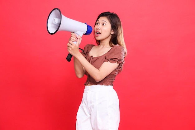 Elegant candid indonesia womans expression shouting with both hands holding an audio megaphone wear