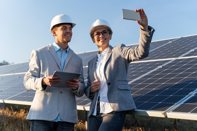 Elegant Caucasian woman and handsome man is working in the solar park outside