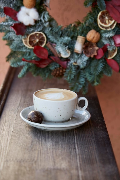 Elegant Christmas wreath and cup of coffee at the terrace Cozy festive home New Year morning