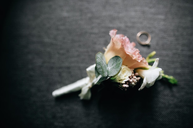 素晴らしいピンクと白の色のバラと結婚式のリングを備えたエレガントで上品な新郎のブートニアx9