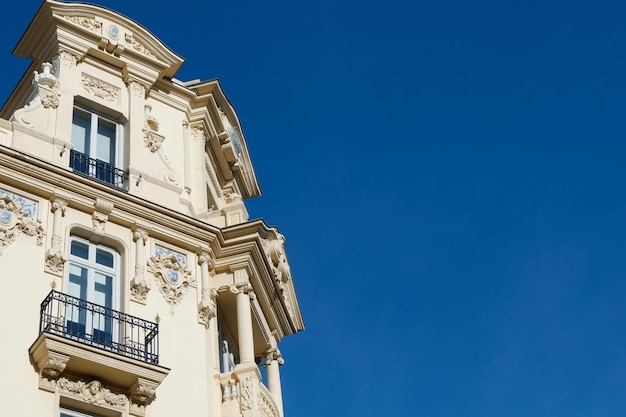 Элегантный угол классического здания с различными окнами и балконами в центре Мадрида, Испания