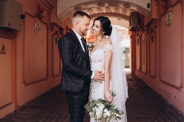 Elegant couple walking at sunset, love story, portrait of bride and groom on wedding day