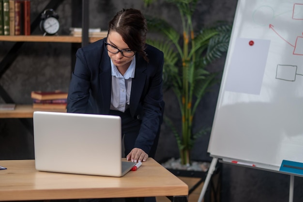 Elegant darkhaired woman typing something on laptop