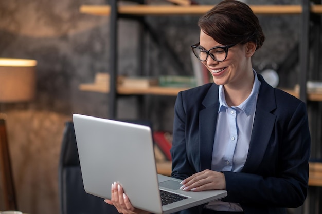 Elegant darkhaired woman with a laptop in hands