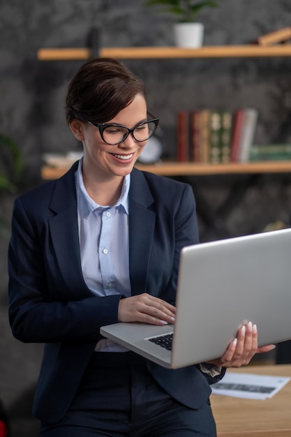 Elegant darkhaired woman with a laptop in hands