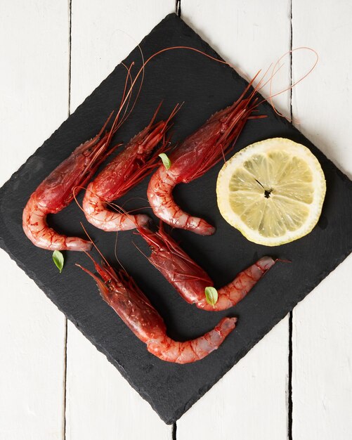 Elegant and Delicious shrimp with cajun seasoning and lime on a black plate Italian Seafood