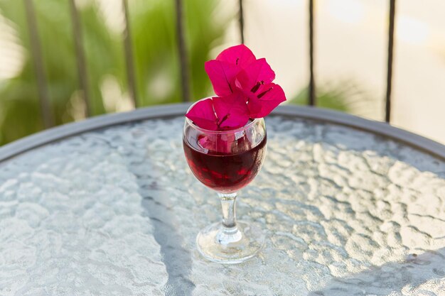 Elegant en kleurrijk glas rode wijn Decoratieve minimalistische roze bloemen van bougainvillea