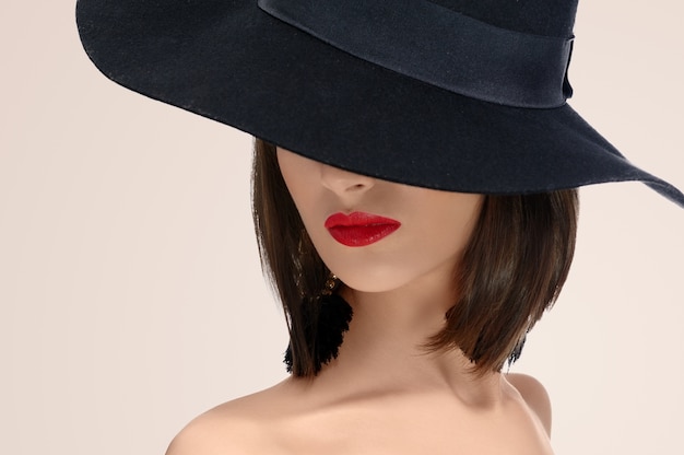 Elegant fashionable woman hide face under a hat