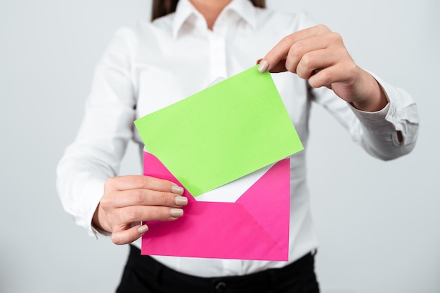 Foto elegante donna professionale in piedi e mettere una lettera con informazioni importanti in busta imprenditrice con cartolina in mano inviando un messaggio cruciale tramite posta