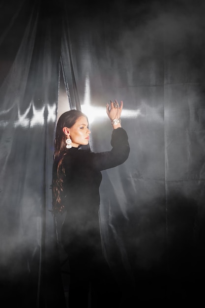 Photo elegant girl in black posing near the curtains closeup