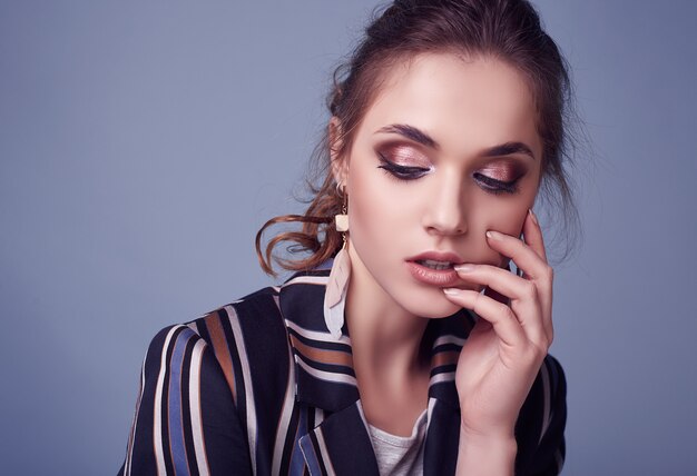 Elegant glamor woman in fashion suit posing on colorful blue 