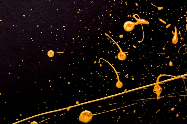 Elegant golden melted paint on black background