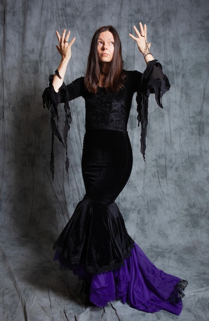 Elegant gothic brunette in a long narrow dress with a train a dress made of black velvet