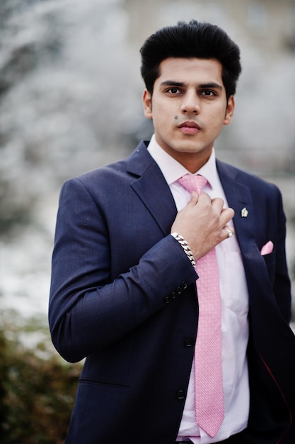 Elegant indian macho man model on suit and pink tie posed on winter day