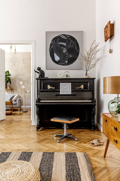 Foto interni eleganti del soggiorno con pianoforte nero, mobili, piante, fiori, orologio in legno, lampada, quadri finti, tappeti, decorazioni e accessori personali nell'arredamento moderno della casa.