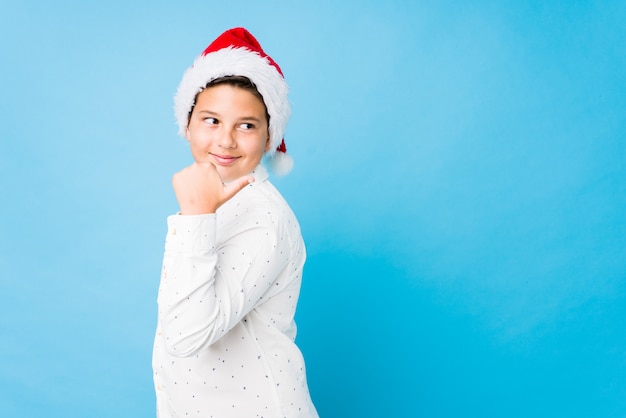 Elegant jong geitje dat een santahoed op een Kerstmisdag draagt