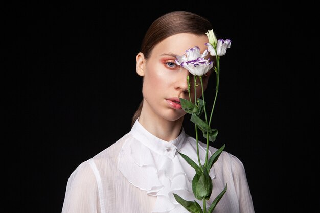 Elegant jong vrouwelijk model met delicate bloemen