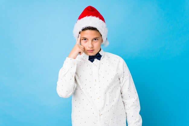 Bambino elegante che porta un cappello di santa un giorno di natale