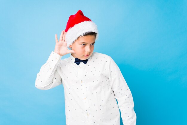 Elegant kid wearing a santa hat on a christmas day