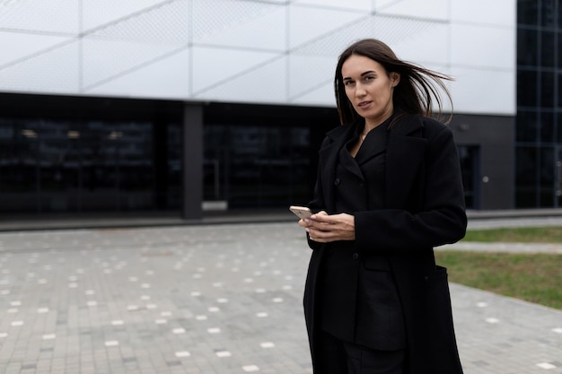 Elegant lady in an urban environment against the backdrop of the building of her work