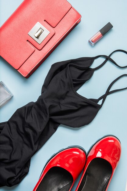 Elegant little women's black dress and red accessories. Flat lay.