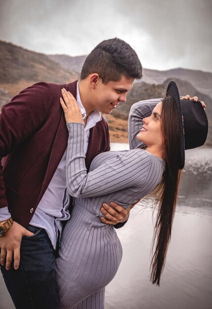 Elegant loving couple staring at each other in a landscape on a lake