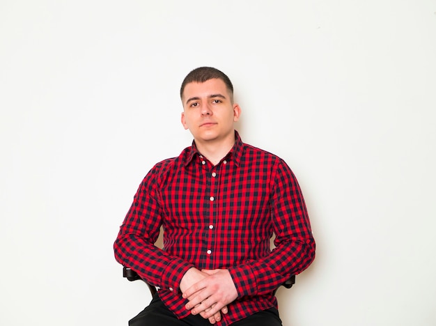 Elegant man siting and posing on brown background. 