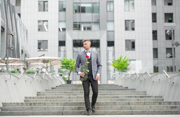 우아한 남자 턱시도 남자 턱시도 bowtie 입고 빨간 장미와 함께 야외 자신감 턱시도 남자