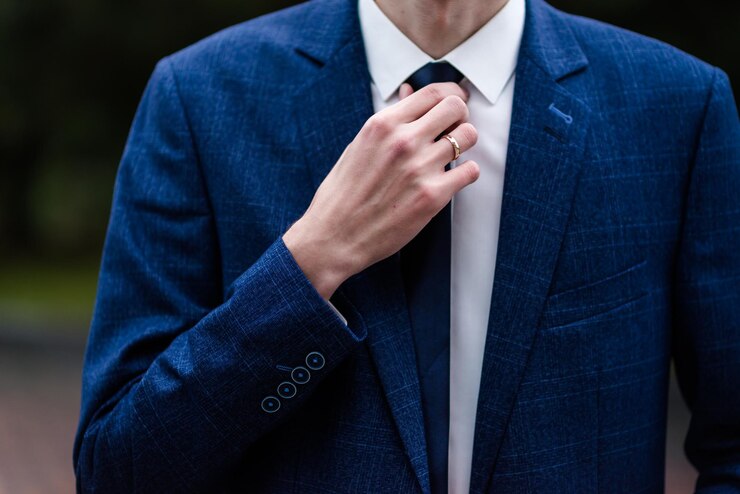 Elegant man tying his tie over black shirt Adjusting tie Black and violet Young business man dressing isolated on black background Groom adjusting his tie