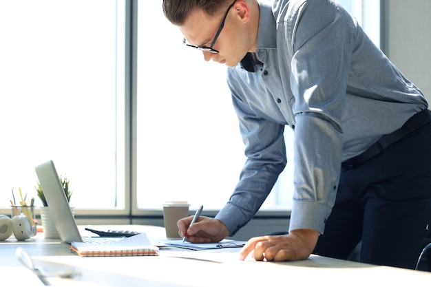 Elegant modern businessman analyzing data while working in office.