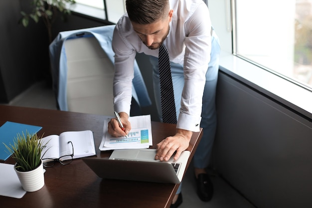 Elegant modern businessman analyzing data while working in office.