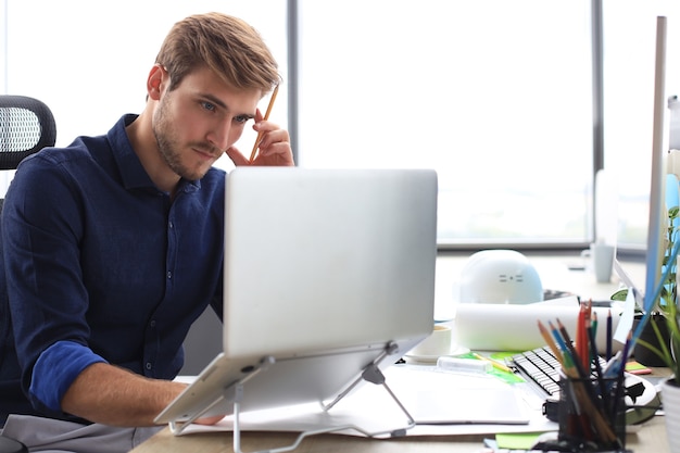 Elegant modern businessman analyzing data while working in office.