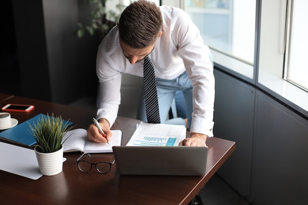 Elegant modern businessman analyzing data while working in office.