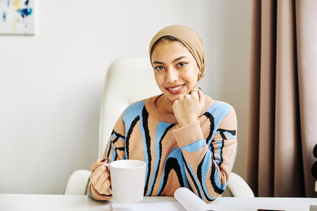 Photo elegant muslim woman as female boss smiling at camera in office