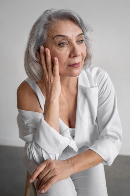 Elegante donna anziana che indossa abiti bianchi