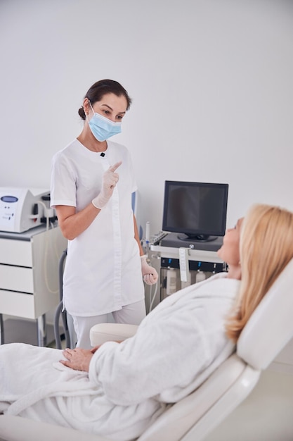 Elegant professional doctor talking with patient in beauty spa center