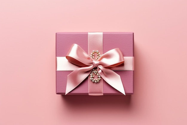 Elegant red gift box beautifully adorned with a golden satin ribbon on a pastel pink background