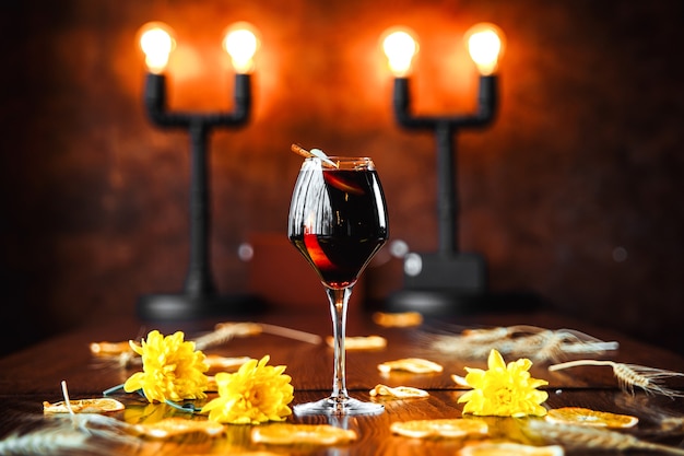 Elegant red wine cocktail on decorated background