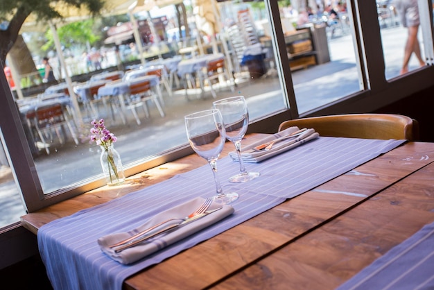 Elegant restaurant table with cutlery, crockery and glasses.