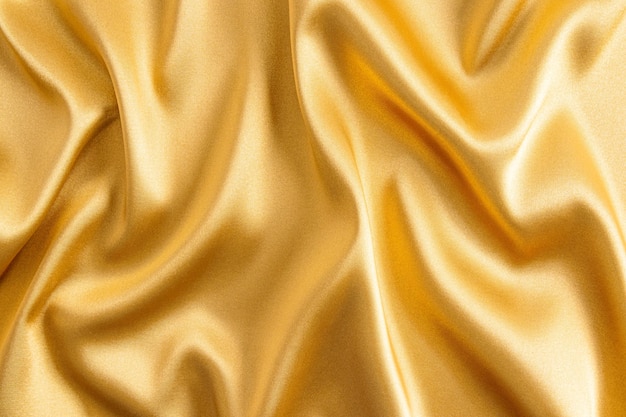 황금색의 우아한 새틴 패브릭 패브릭의 부드러운 주름의 고급스러운 질감 축제 배경 디자인의 개념