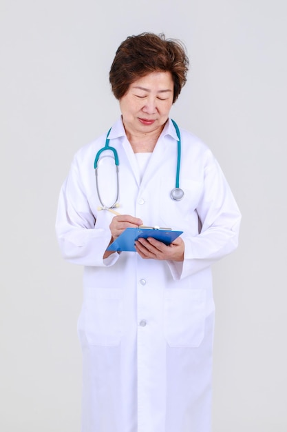 Elegant senior female doctor on physician gown confidently standing as hospitally health expert for disease treatment at clinic.