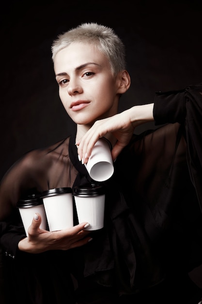 Elegant short haired woman holding cups of coffee