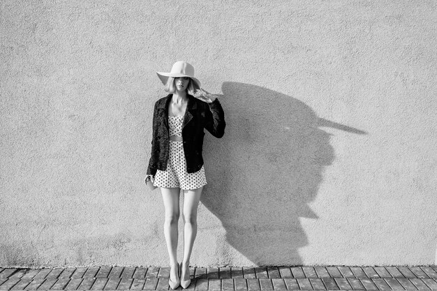 Elegant stylish blonde short hair girl in hat and dress posing with coffee over white background