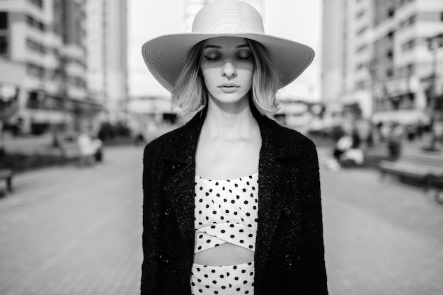 Elegant stylish blonde short hair woman hat posing over street background